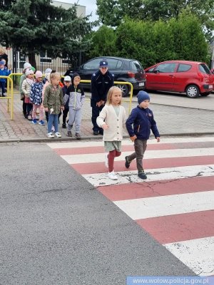 Funkcjonariuszka przeprowadzająca dzieci przez przejście dla pieszych