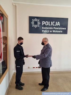 Komendant Powiatowy Policji w Wołowie wręczający akt mianowania funkcjonariuszowi