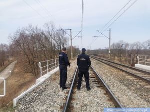 Funkcjonariusz Służby Ochrony Kolei oraz Funkcjonariusz Policji stojący przy torowisku