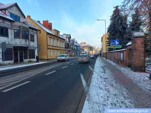 droga w mieście, po bokach zaśnieżone chodniki, na drodze samochody