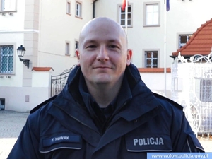 policjant w mundurze na tle budynków