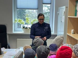 Na zdjęciu widzimy grupę dzieci oraz policjantkę.