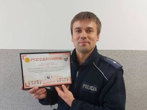 Na zdjęciu widzimy policjanta z podziękowaniem od przedszkolaków.