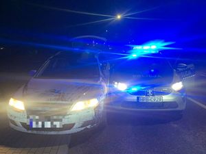 Na zdjęciu widzimy samochód osobowy oraz radiowóz w trakcie kontroli drogowej.