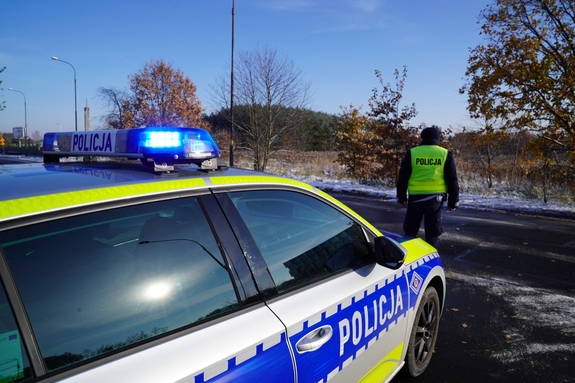 Na zdjęciu widzimy radiowóz oraz policjanta.