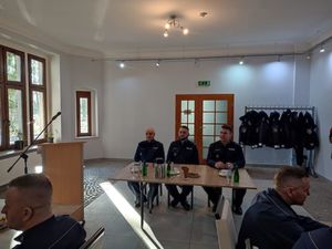 Na zdjęciu widzimy trzech policjantów siedzących przy stole.