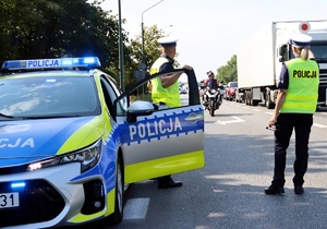 Na zdjęciu widzimy policjantów stojących przy radiowozie.