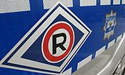 Na zdjęciu widzimy literę R koloru czerwonego w rombie czyli symbol Wydziału Ruchu Drogowego.