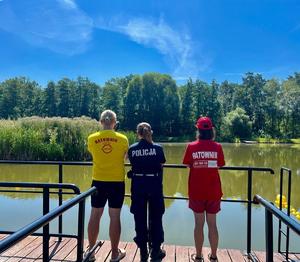 Na zdjęciu widzimy policjantkę oraz ratownika nad akwenem.