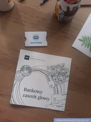 materiały w postaci książeczki informacyjnej oraz nakładki na kartę bankomatową przekazane seniorom podczas spotkania